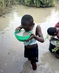 A child collecting water from a river